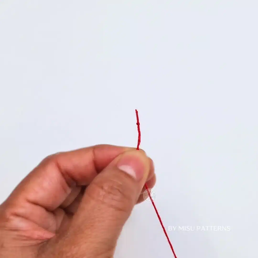 Pull the thread gently until a small knot forms at the end.