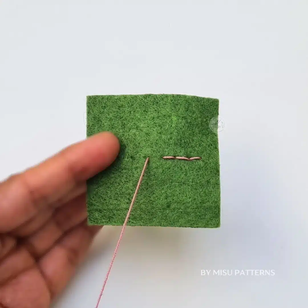 Close-up of even backstitches on felt forming a clean and professional-looking line.