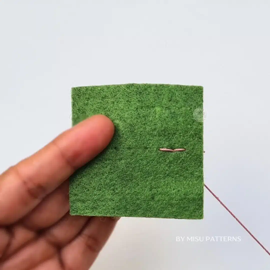 First backstitch completed in felt showing the initial stitch of the technique.