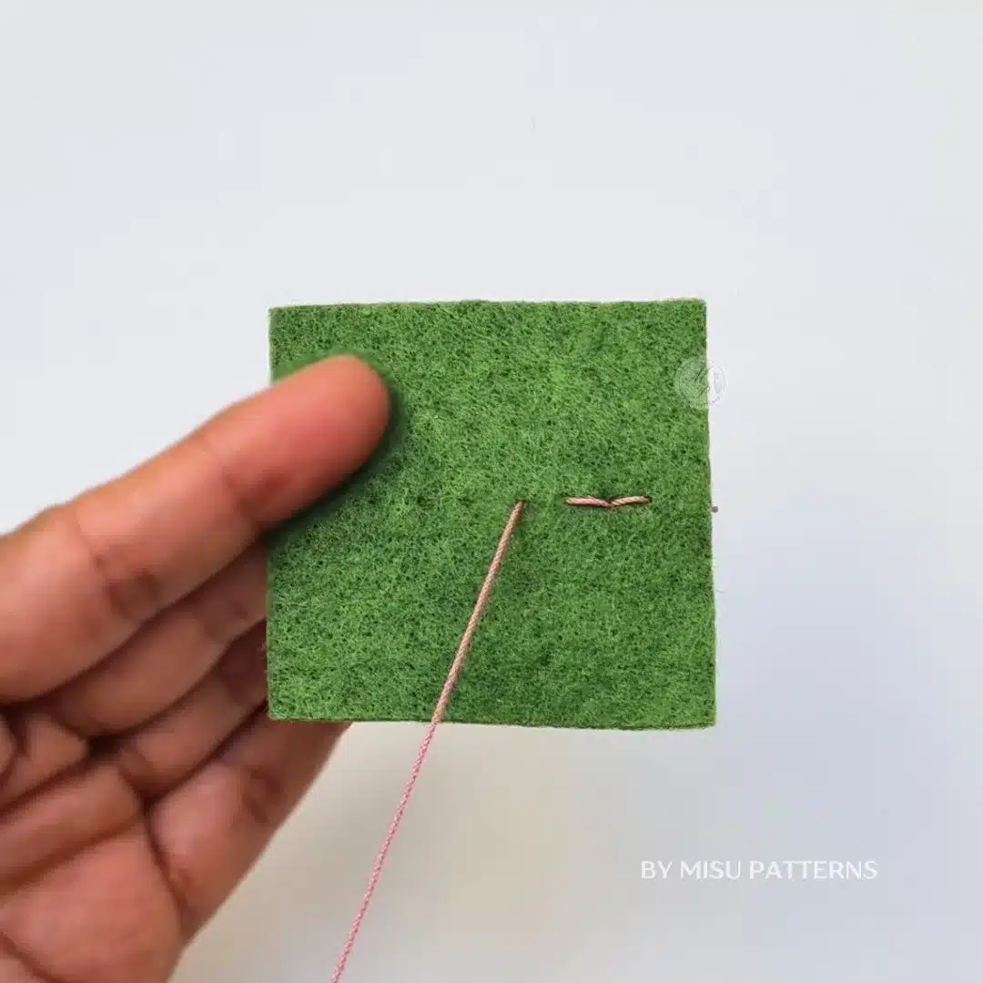 Hand sewing backstitch on felt, continuing forward one step and returning into the previous stitch.