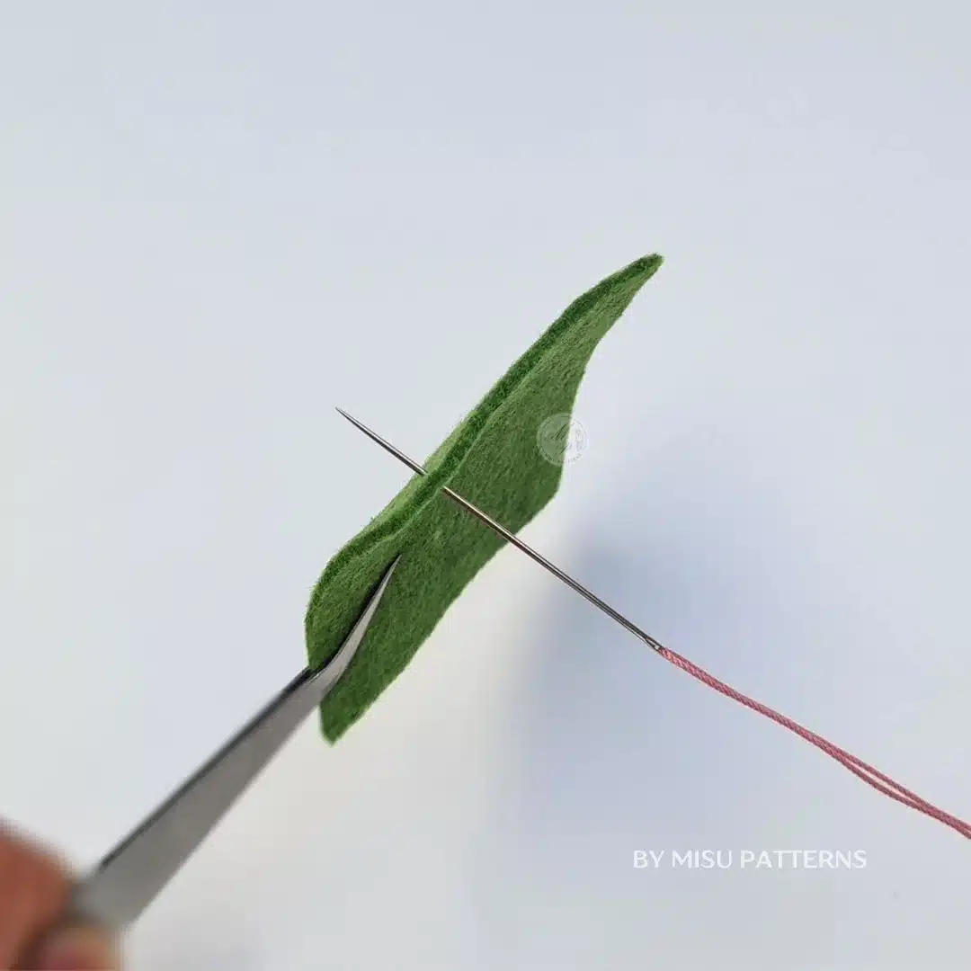 Push the needle up from the back of the fabric to the front.