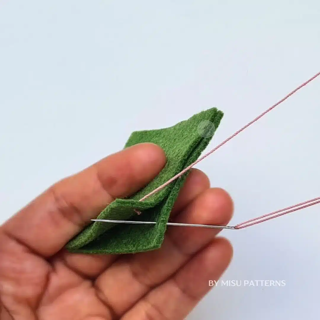 Moving the sewing needle to the back of the fabric to start the blanket stitch loop.