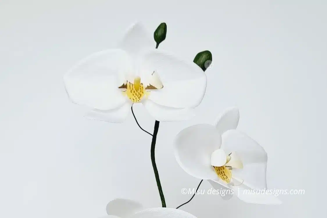 Close-up of handmade crepe paper orchid with delicate details, painted with pan pastel